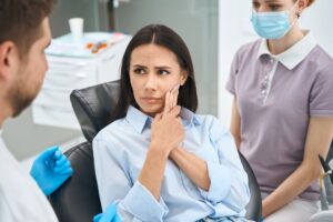 anxious patient explaining tooth pain to dentist